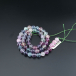 Facettierter 4A+ Qualität Regenbogen-Fluorit-Natursteinstrang in 8mm Größe mit lila und grünen Verläufen, vorbereitet für das Schmuckdesign.