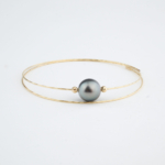 18k gold double-wire bracelet featuring a luxurious original black Tahitian pearl in the center.