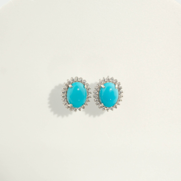 Orecchini di design di lusso realizzati con pietre di turchese naturale a taglio cabochon ovale incastonate in argento sterling 925 con halo di zirconi.