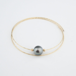 Bracelet de luxe en fil d'or double 18k avec une perle de Tahiti noire originale au centre.