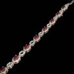 Bracelet flexible en argent sterling 925 orne de pierres de rubis rouge coupe ovale originales et d'accents de zircon brillant.