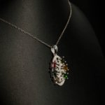 A luxury designer necklace featuring original faceted oval multicolor tourmaline gemstones arranged in a sterling silver filigree pendant with zircon accents.