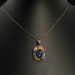Ciondolo di design di lusso in argento sterling 925 con uno zaffiro stellato cabochon ovale circondato da un alone di zaffiri colorati sfaccettati.