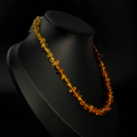 Women's necklace with original amber natural stones arranged from dark to light colors, featuring a steel clip.