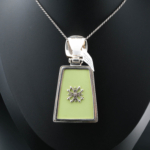 Collana da collezione realizzata a mano in argento sterling 925 con pietra d'ambra naturale originale a forma di trapezio, decorata con smalto verde pistacchio ed eleganti motivi in argento.
