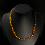 Collier pour femme avec pierres naturelles d'ambre original disposées de couleurs foncées à claires, avec fermoir en acier.