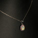 A luxury designer jewelry set including a ring, earrings, and necklace made of original oval cabochon opals surrounded by a multicolor sapphire halo in 925 sterling silver.