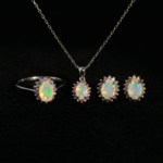 Juego de joyas de lujo en plata de ley 925 que incluye anillo, pendientes y colgante adornados con ópalos cabujón y zafiros de colores.