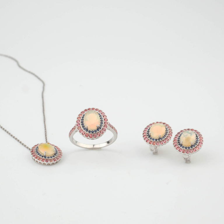 Juego de joyas de lujo en plata de ley 925 que incluye anillo, pendientes y colgante adornados con ópalos cabujón, zafiros azules y granates rosas.