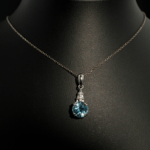 A luxury designer necklace featuring an original faceted round blue topaz gemstone set in 925 sterling silver with zircon accents.