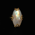 A luxury women's statement ring featuring an original oval cabochon moonstone with blue sheen set in a gold-plated 925 sterling silver artisan prong design.