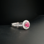 A delicate women's statement ring featuring a round-cut original ruby gemstone surrounded by cubic zirconia in 925 sterling silver.