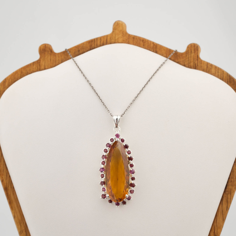 A luxury designer necklace featuring an original marquise faceted citrine surrounded by a pink tourmaline halo in 925 sterling silver.