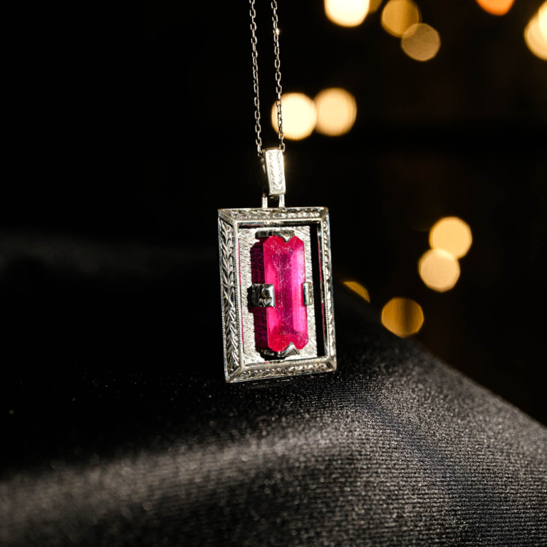 Collana in argento 925 con una pietra naturale di rubino originale con taglio a faccette rettangolare in una cornice rettangolare con motivi floreali fatti a mano.