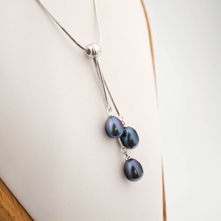 Pendentif de luxe en acier inoxydable orné de trois perles noires de culture d'océan en forme de goutte.