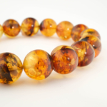 Bracelet orné de perles rondes de 12-13mm en ambre baltique naturelle originale aux reflets chauds.
