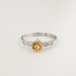 A luxury women's five-stone style ring featuring an original round faceted yellow citrine gemstone set in 925 sterling silver.