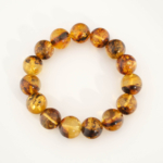 Bracelet orné de perles rondes de 13-14mm en ambre baltique naturelle originale aux reflets chauds.