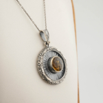 Halskette aus 925er Sterlingsilber mit einem rund facettierten, originalen Citrin-Naturstein, strahlenden Silberdetails und handgefertigten Motiven.