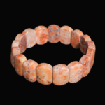 Oval cut rolex original fossil coral natural stone bracelet in orange and terracotta tones with speckled fossil patterns.