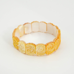 Bracelet de luxe en nacre naturelle jaune sculptée de motifs roses avec maillons style Rolex.