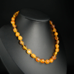 A certified natural honey Baltic amber baby teething necklace featuring large smooth beads (9-11gr).