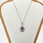 Pendentif pour femme en améthyste violette naturelle ovale et argent sterling 925 brillant sur tissu blanc.