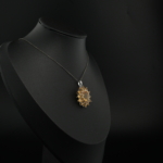 Pendentif fleur pour femme en citrine jaune naturelle fasetée et argent sterling 925 sur tissu blanc.