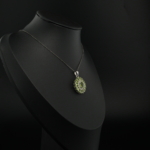 Pendentif fleur pour femme en péridot vert naturel et argent sterling 925 brillant sur tissu blanc.