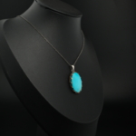 Pendentif unisexe en turquoise naturelle d'Arizona ovale et argent 925 sur tissu blanc satiné.