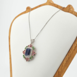 Damen Luxus Halskette aus 925 Silber mit Baguette Saphir, rosa Turmalin, grünem Tsavorit und Diamanten auf weißer Seide.