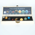 Coffret en bois avec 9 sphères en pierres naturelles représentant les planètes du système solaire.