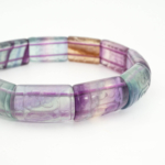 An authentic hand-carved rainbow fluorite rolex cut gemstone stretch bracelet for men and women.