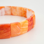 Ylellinen luonnollinen oranssi helmiäisrannekoru rolex-muotoilulla.