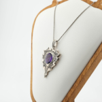 Natural oval purple amethyst gemstone gothic shield pendant in oxidized 925 sterling silver on white silk.