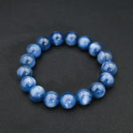 A premium natural blue kyanite gemstone stretch bracelet featuring smooth 11-12mm round beads.