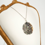 An authentic hand-carved grey mother of pearl rose pendant necklace with silver tone stainless steel chain.