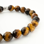 An authentic 8mm faceted cut natural tiger's eye beaded stretch bracelet with silver tone accent.