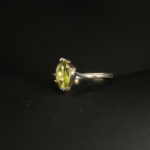 A 925 sterling silver women's ring featuring a natural marquise-shaped faceted green peridot gemstone in a prong setting.