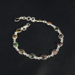 A delicate 925 sterling silver chain bracelet featuring multicolor oval cabochon natural tourmaline gemstones.