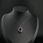 Natural purple faceted oval amethyst gemstone halo pendant necklace in 925 sterling silver on white silk.