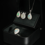 A luxurious 925 sterling silver women's jewelry set with pear-shaped cabochon rainbow opal and halo stones.