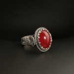 A handcrafted 925 sterling silver men's ring featuring a vibrant red Ottoman amber gemstone with engraved antique patterns.