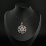 Natural red faceted ruby gemstone lace medallion pendant necklace in 925 sterling silver on white silk.