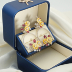 A luxurious pair of 925 sterling silver statement dangle earrings with natural red rubies and carved yellow mother-of-pearl flowers.