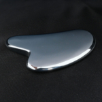 A natural metallic mirror-finish heart-shaped terahertz stone Gua Sha facial massage tool.