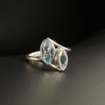 A 925 sterling silver women's ring featuring two natural marquise-shaped faceted blue topaz gemstones in a smooth bezel setting.