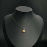 Natural round yellow sapphire gemstone halo pendant necklace in 925 sterling silver on white silk.