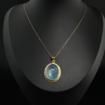 Gold plated 925 sterling silver women necklace featuring an oval cabochon natural blue aquamarine with zircon halo.
