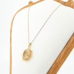 Gold plated 925 sterling silver women necklace featuring an oval cabochon natural gold rutilated quartz in floral frame.